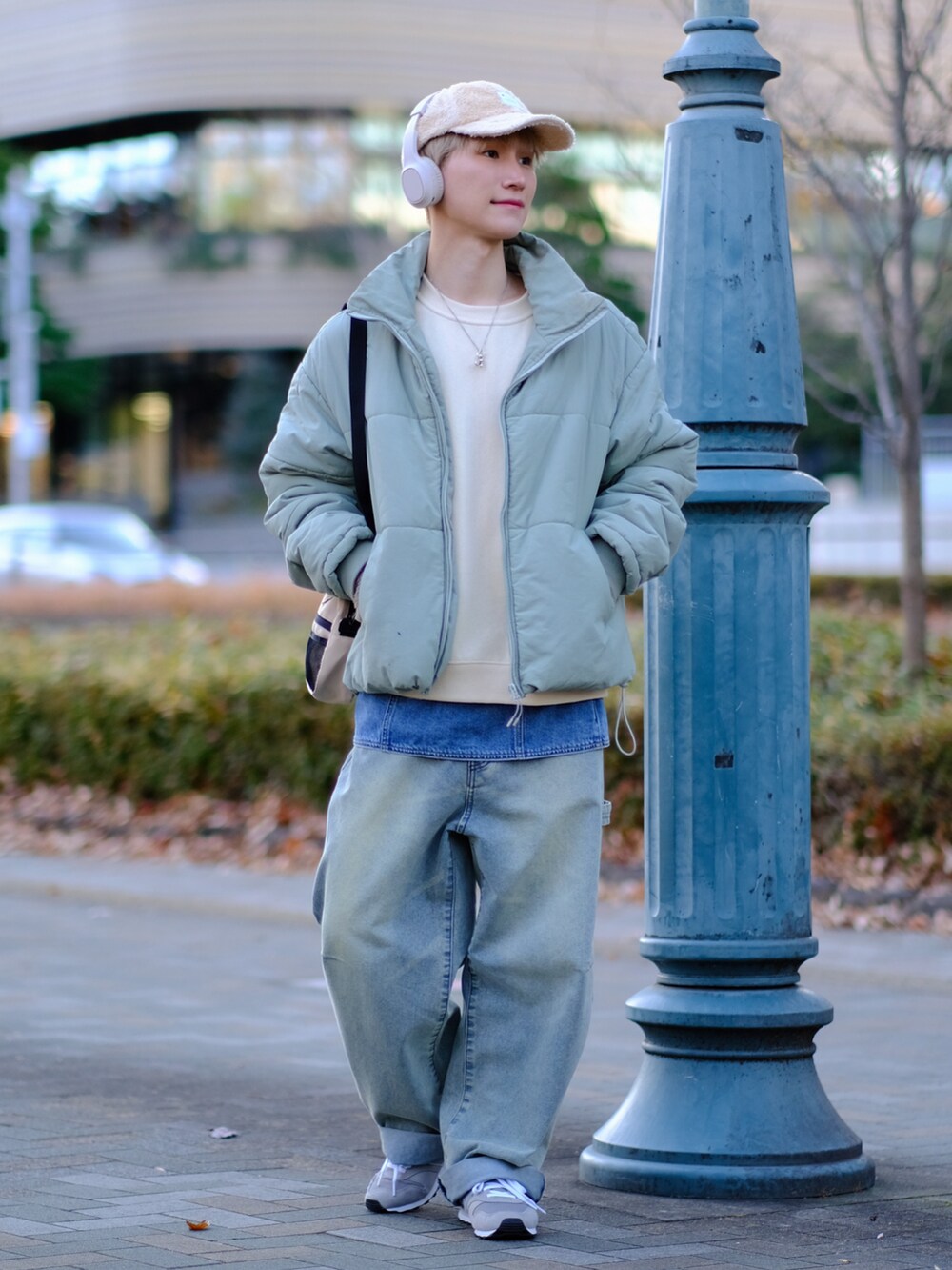 ブルー系のデニムパンツ、グレー系のスニーカー、ベージュ系のスウェットを着用したメンズの冬コーディネートの5枚目の写真