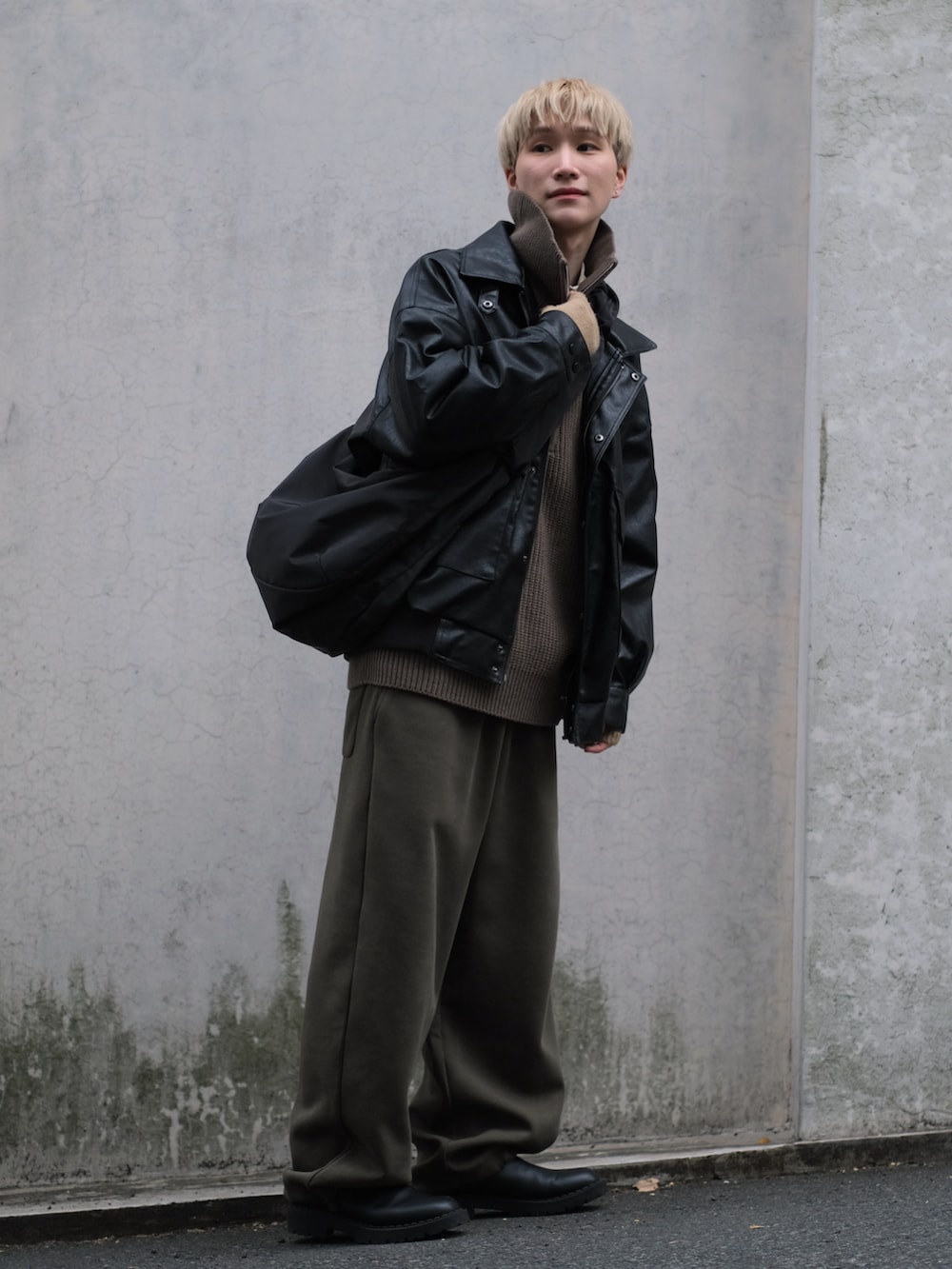 グリーン系のスウェットパンツ、ブラック系のブルゾン、ブラウン系のニット/セーターを着用したメンズの冬コーディネートの3枚目の写真