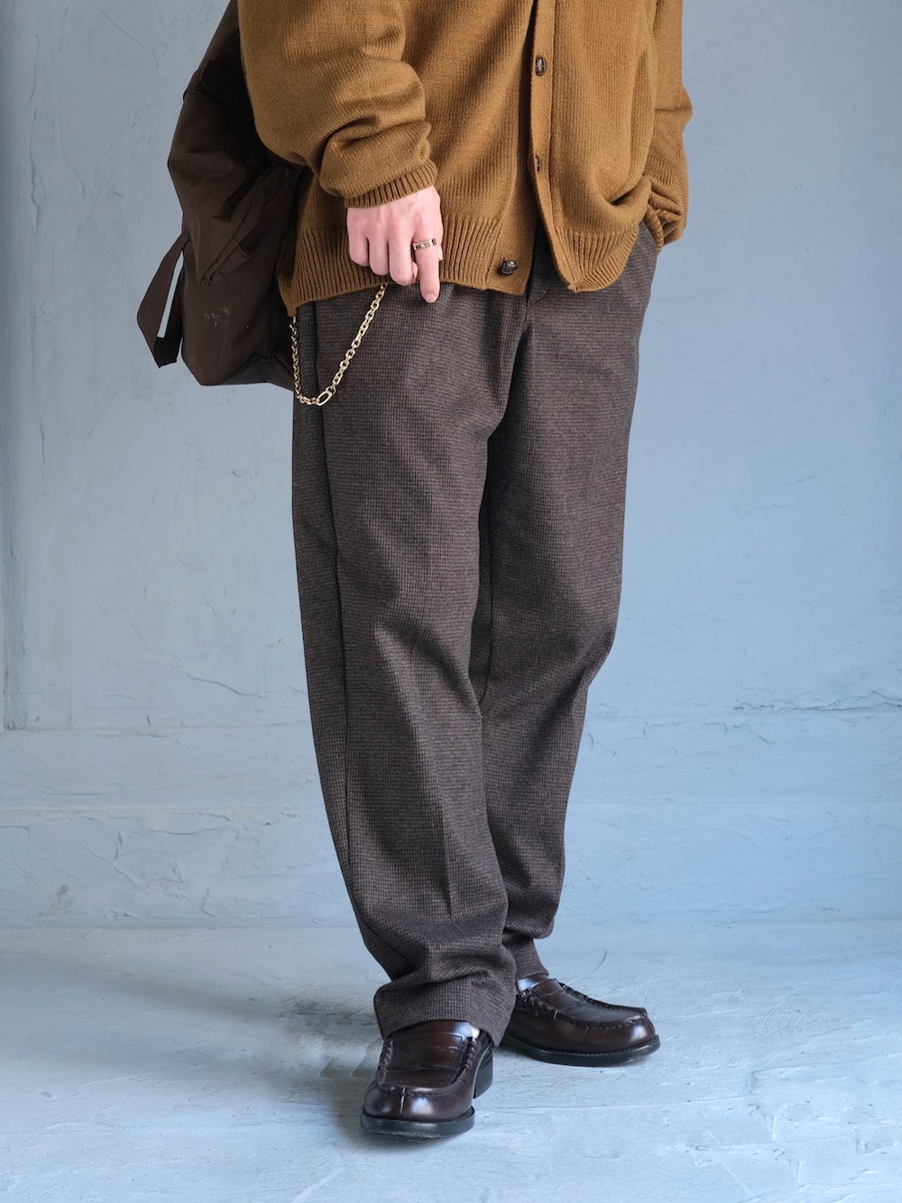 ブルー系のTシャツ/カットソー、イエロー系のカーディガン/ボレロ、ブラウン系のスラックスを着用したメンズの秋コーディネートの4枚目の写真