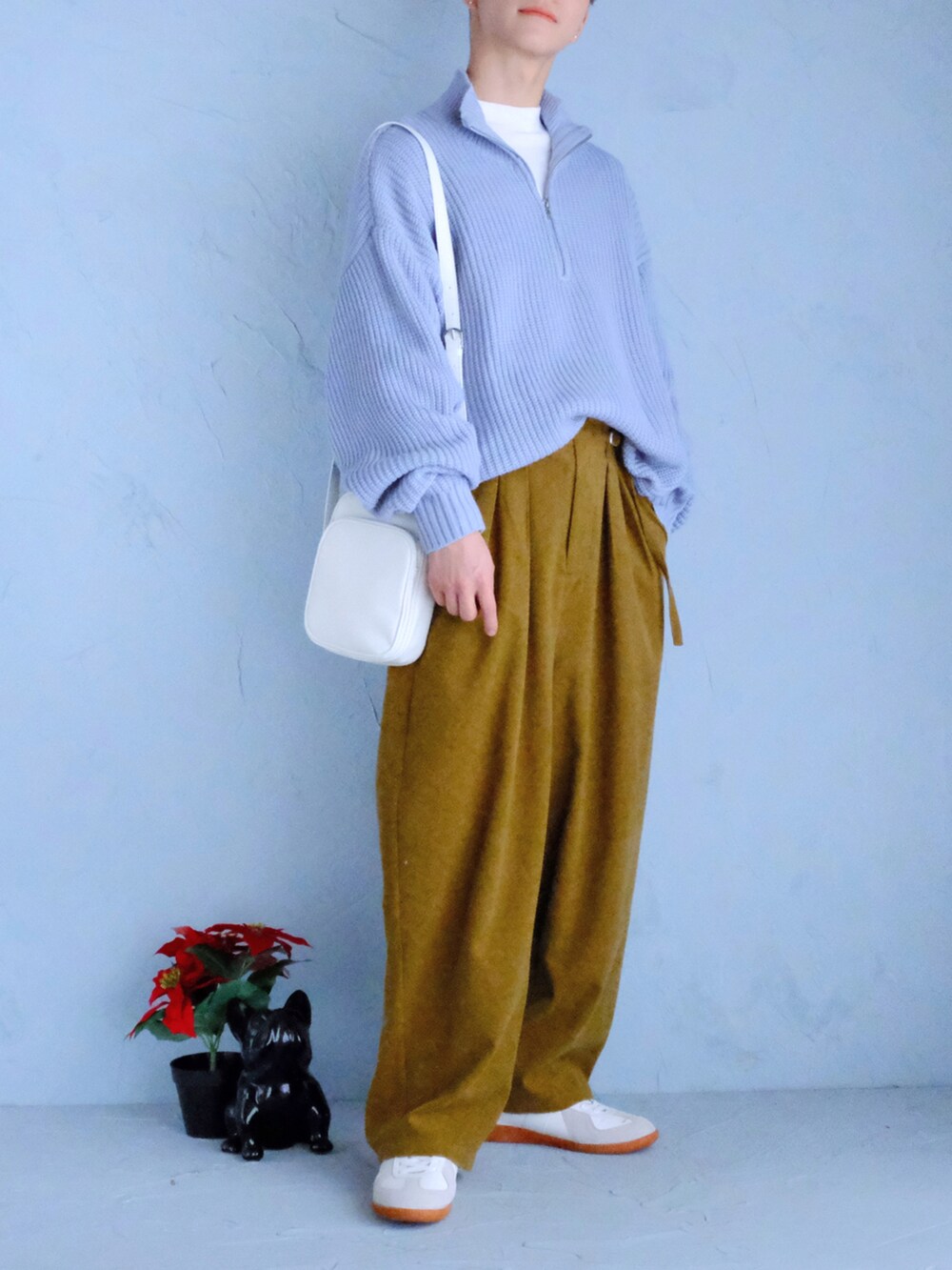 ホワイト系のスニーカー、イエロー系のスラックス、ホワイト系のショルダーバッグを着用したメンズの冬コーディネートの2枚目の写真