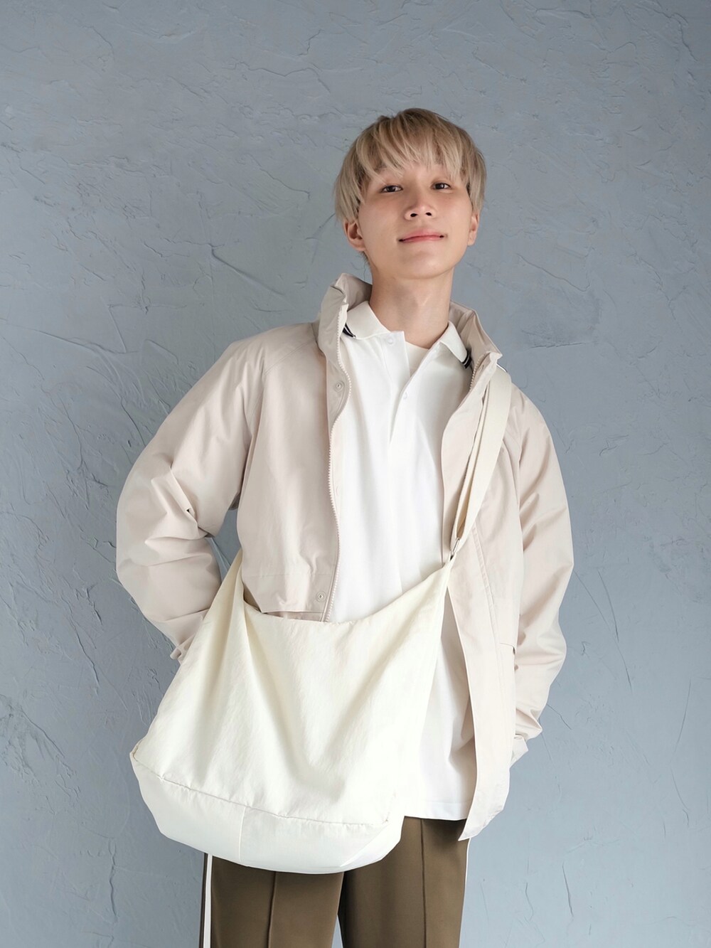 レッド系のスニーカー、グリーン系のその他パンツ、ホワイト系のブルゾンを着用したメンズの冬コーディネートの2枚目の写真