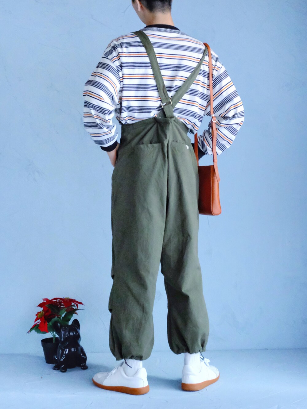 ホワイト系のスニーカー、グリーン系のその他パンツ、ホワイト系のTシャツ/カットソーを着用したメンズの冬コーディネートの3枚目の写真