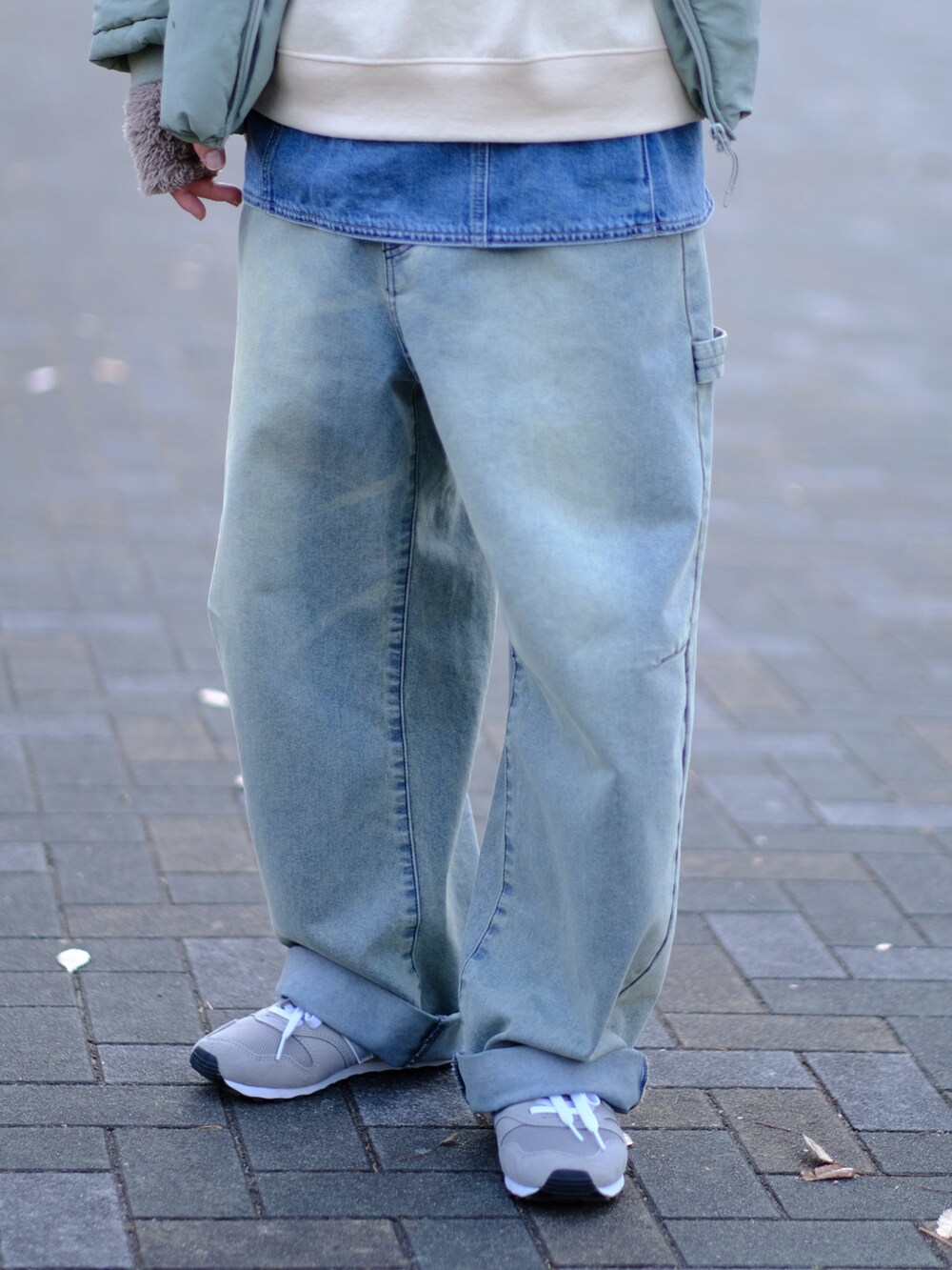 ブルー系のデニムパンツ、グレー系のスニーカー、ベージュ系のスウェットを着用したメンズの冬コーディネートの2枚目の写真