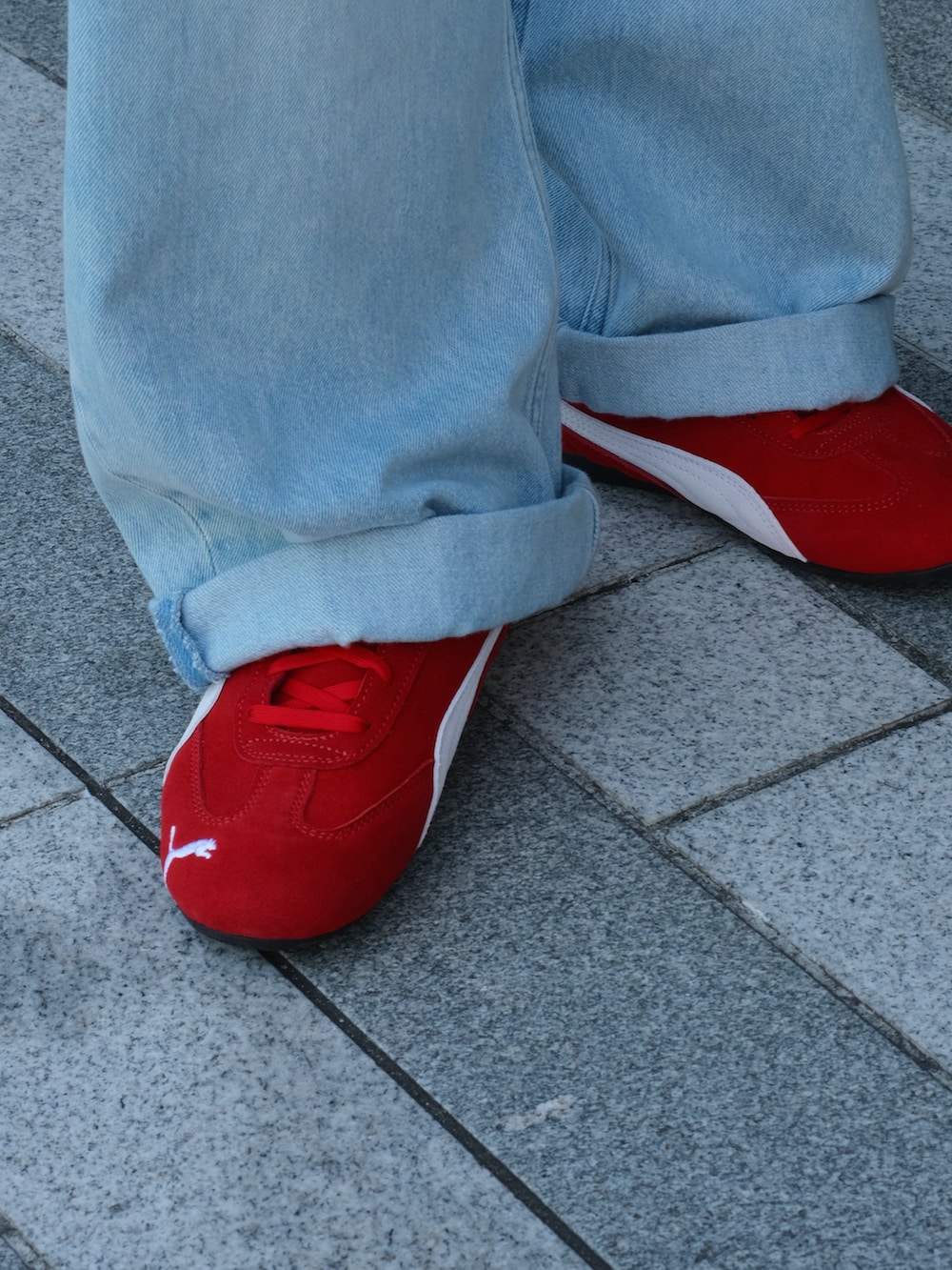 レッド系のスニーカー、ブルー系のTシャツ/カットソー、ブルー系のデニムパンツを着用したメンズの夏コーディネートの2枚目の写真