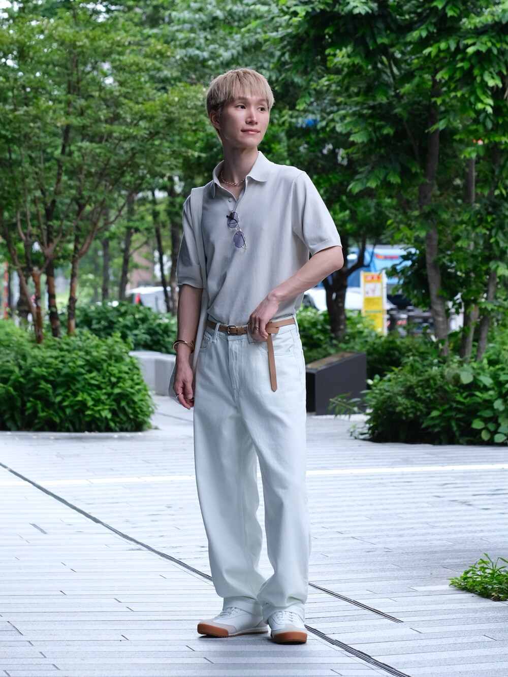 ホワイト系のデニムパンツ、ホワイト系のポロシャツ、ホワイト系のスニーカーを着用したメンズの夏コーディネートの2枚目の写真