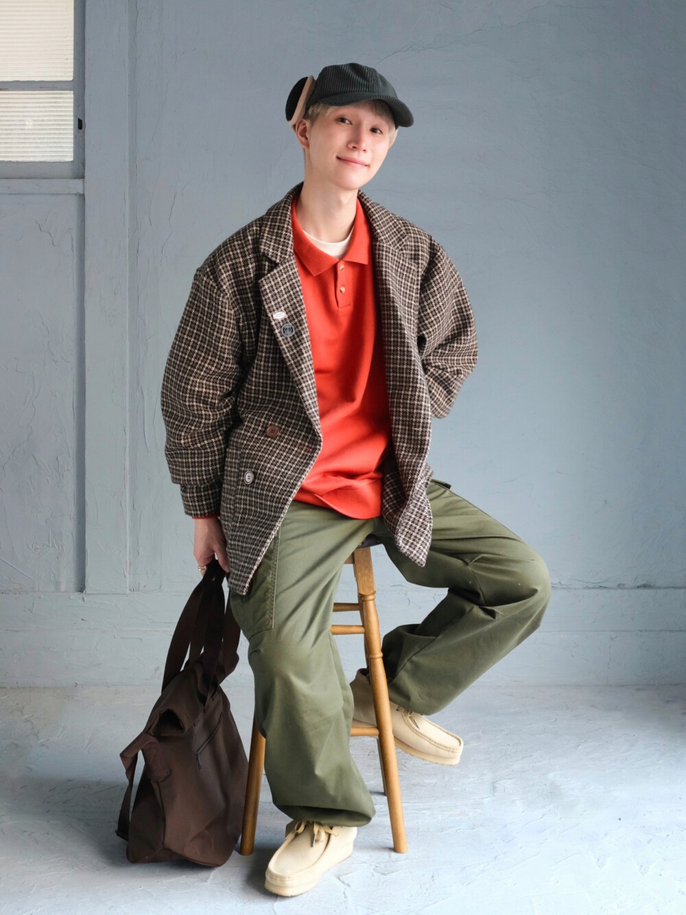 グリーン系のカーゴパンツ、ベージュ系のブーツ、ブラウン系のトートバッグを着用したメンズの秋コーディネートの2枚目の写真