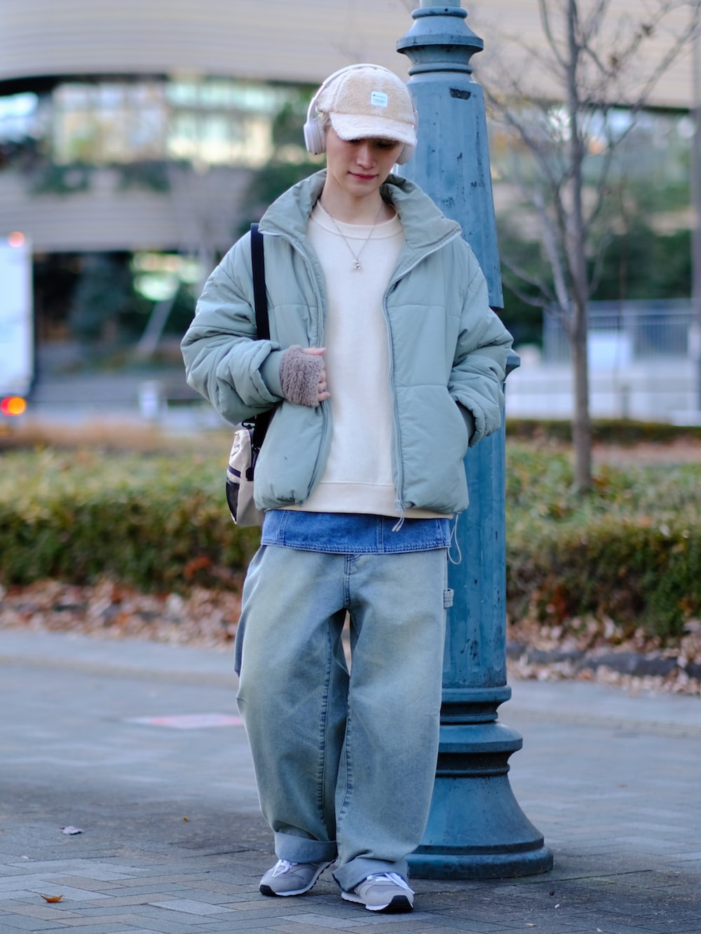 ブルー系のデニムパンツ、グレー系のスニーカー、ベージュ系のスウェットを着用したメンズの冬コーディネートの3枚目の写真