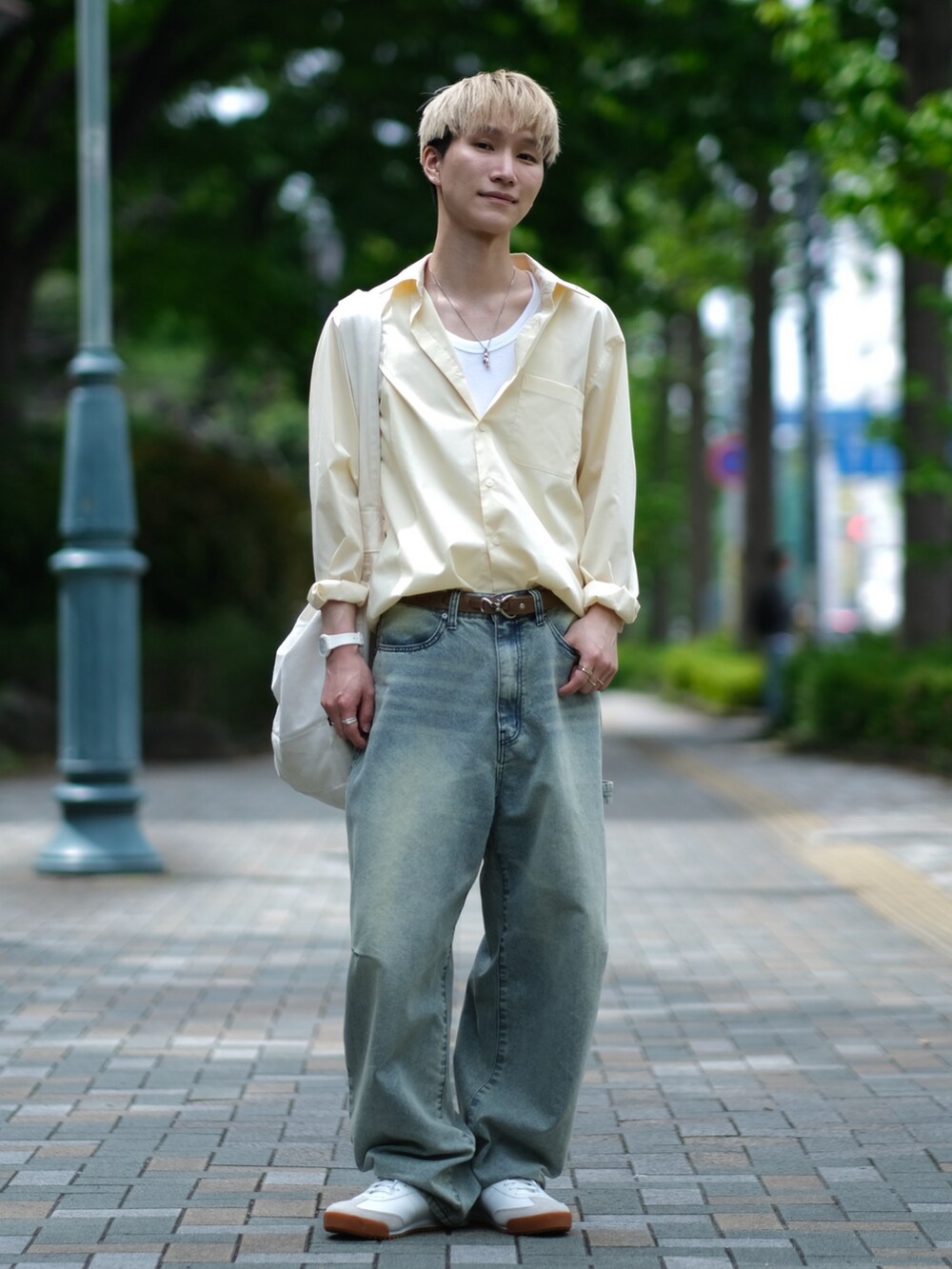 ブルー系のデニムパンツ、イエロー系のシャツ/ブラウス、ホワイト系のスニーカーを着用したメンズの夏コーディネートの2枚目の写真