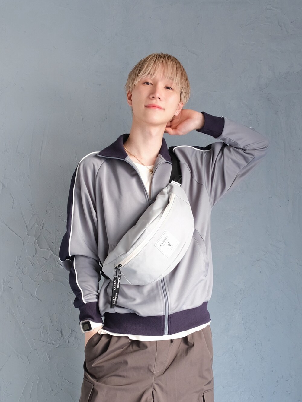 グレー系のカーゴパンツ、ブルー系のジャージ、グレー系のボディバッグ/ウエストポーチを着用したメンズの春コーディネートの2枚目の写真