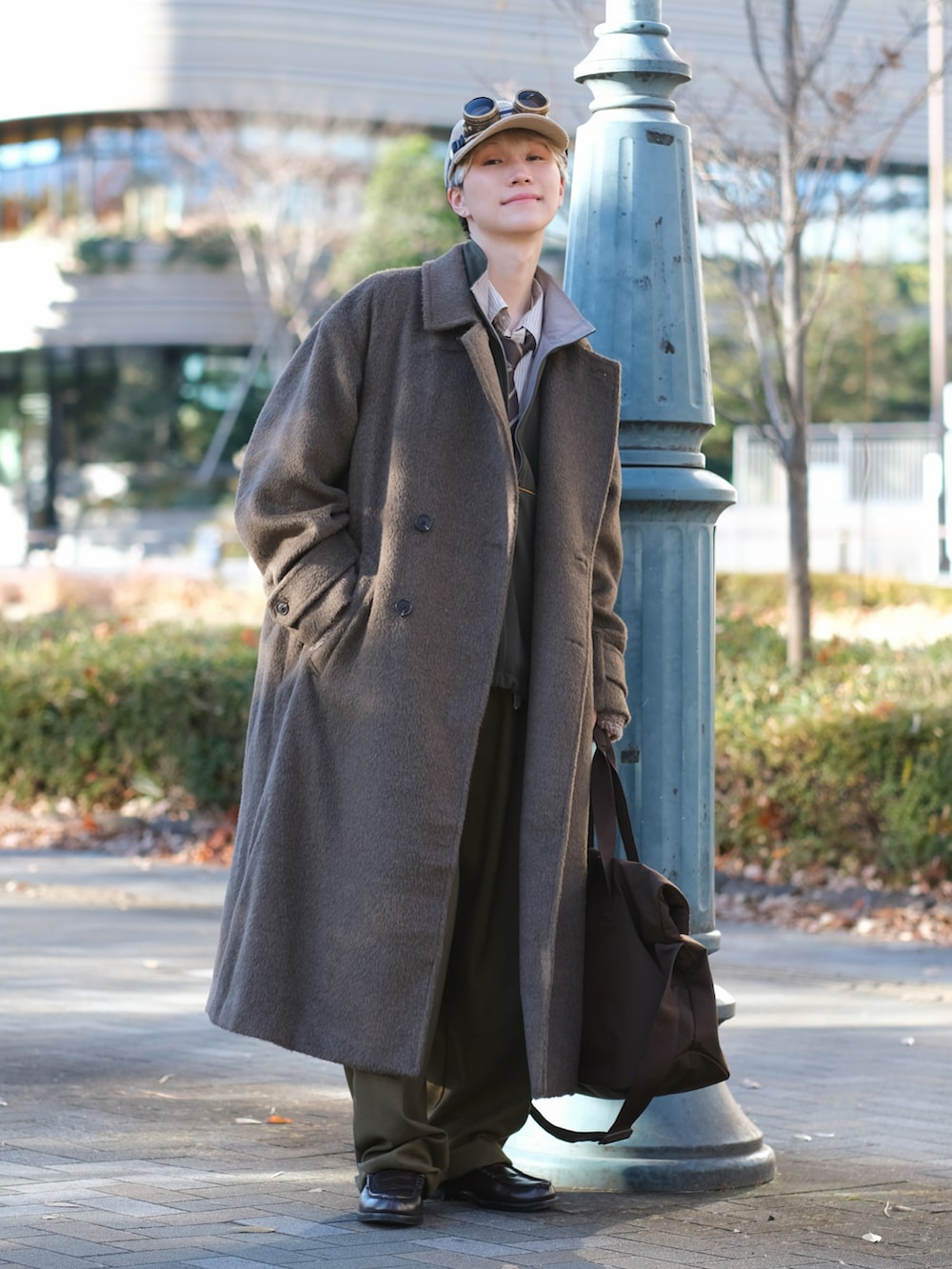 ブラウン系のチェスターコート、グリーン系のスウェットパンツ、ブラウン系のローファーを着用したメンズの冬コーディネートの3枚目の写真