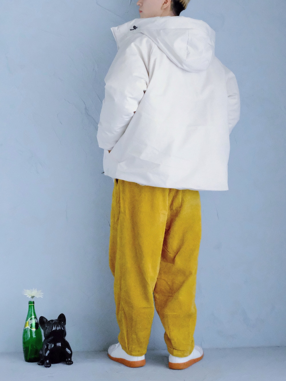 ホワイト系のスニーカー、イエロー系のその他パンツ、オレンジ系のショルダーバッグを着用したメンズの冬コーディネートの3枚目の写真