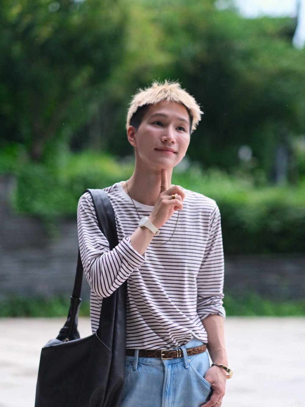 レッド系のTシャツ/カットソー、ブルー系のデニムパンツ、ブラウン系のショルダーバッグを着用したメンズの夏コーディネートの2枚目の写真