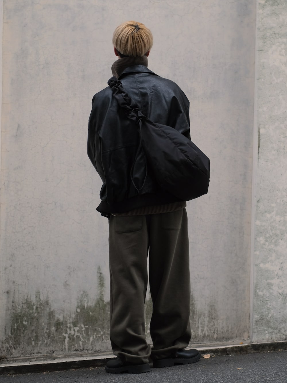 グリーン系のスウェットパンツ、ブラック系のブルゾン、ブラウン系のニット/セーターを着用したメンズの冬コーディネートの5枚目の写真