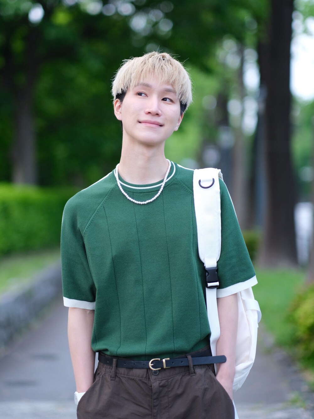 グリーン系のニット/セーター、ブラウン系のカーゴパンツ、ホワイト系のスニーカーを着用したメンズの夏コーディネートの4枚目の写真