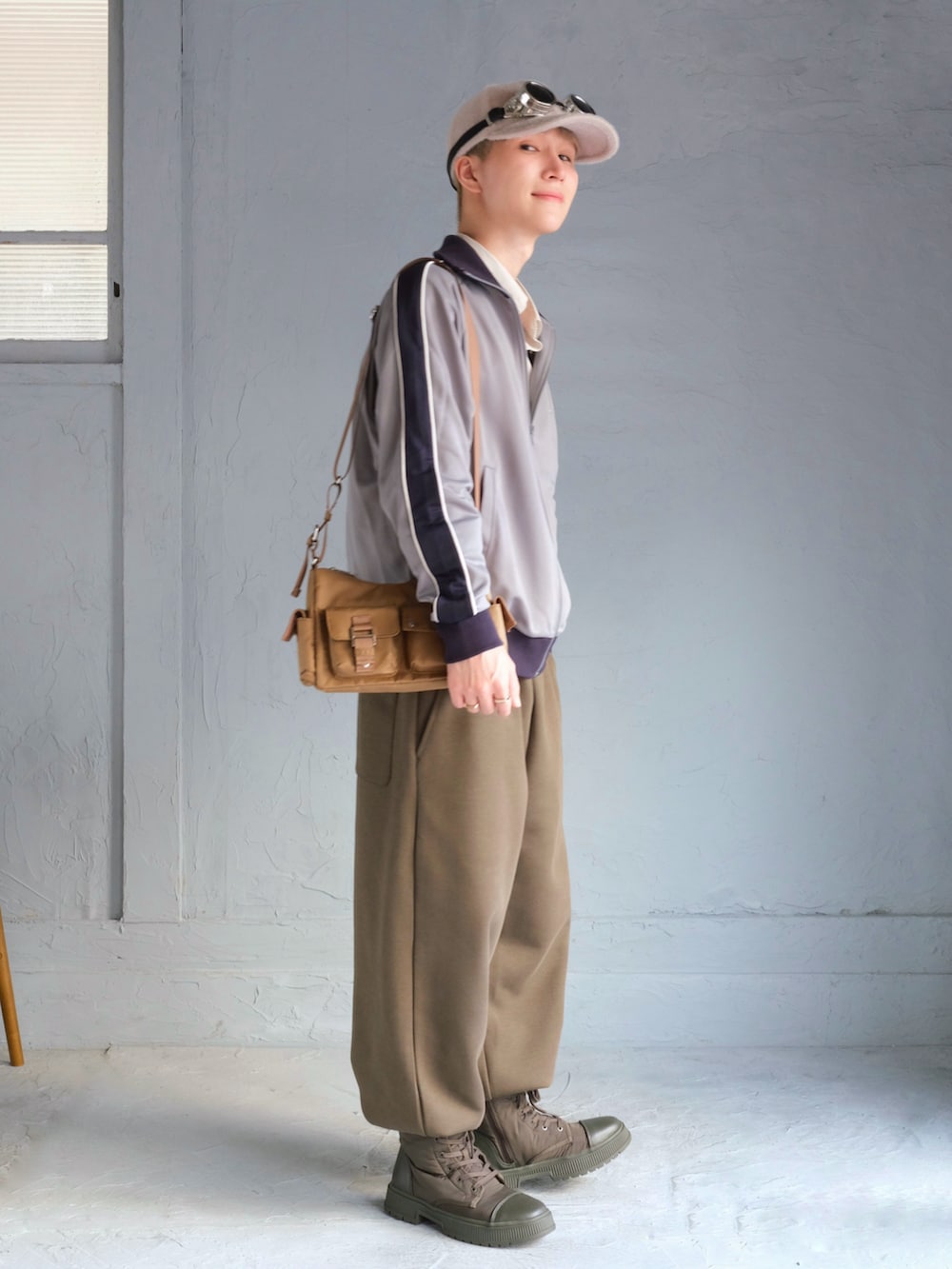 ブルー系のジャージ、ベージュ系のショルダーバッグ、グリーン系のスウェットパンツを着用したメンズの秋コーディネートの4枚目の写真