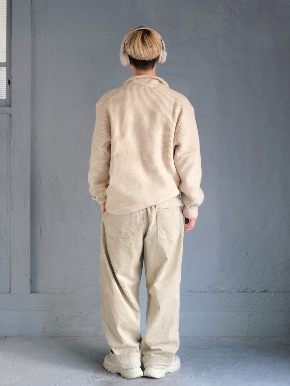 ホワイト系のニット/セーター、ベージュ系のその他パンツ、ホワイト系のスニーカーを着用したメンズの冬コーディネートの5枚目の写真