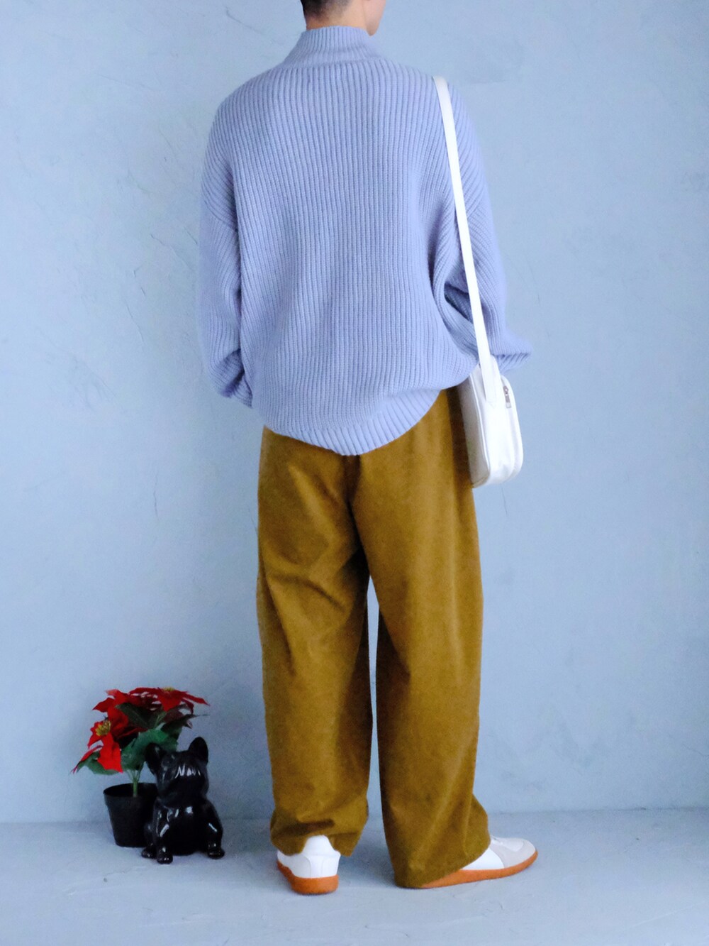 ホワイト系のスニーカー、イエロー系のスラックス、ホワイト系のショルダーバッグを着用したメンズの冬コーディネートの3枚目の写真