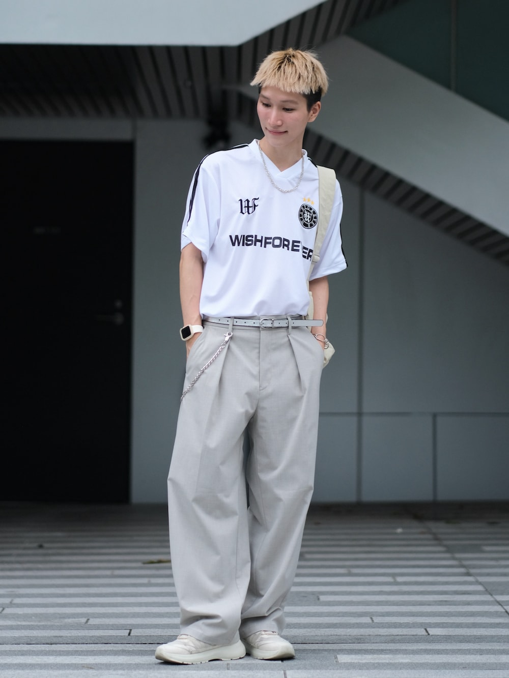 ホワイト系のTシャツ/カットソー、グレー系のスラックス、ホワイト系のスニーカーを着用したメンズの夏コーディネートの5枚目の写真