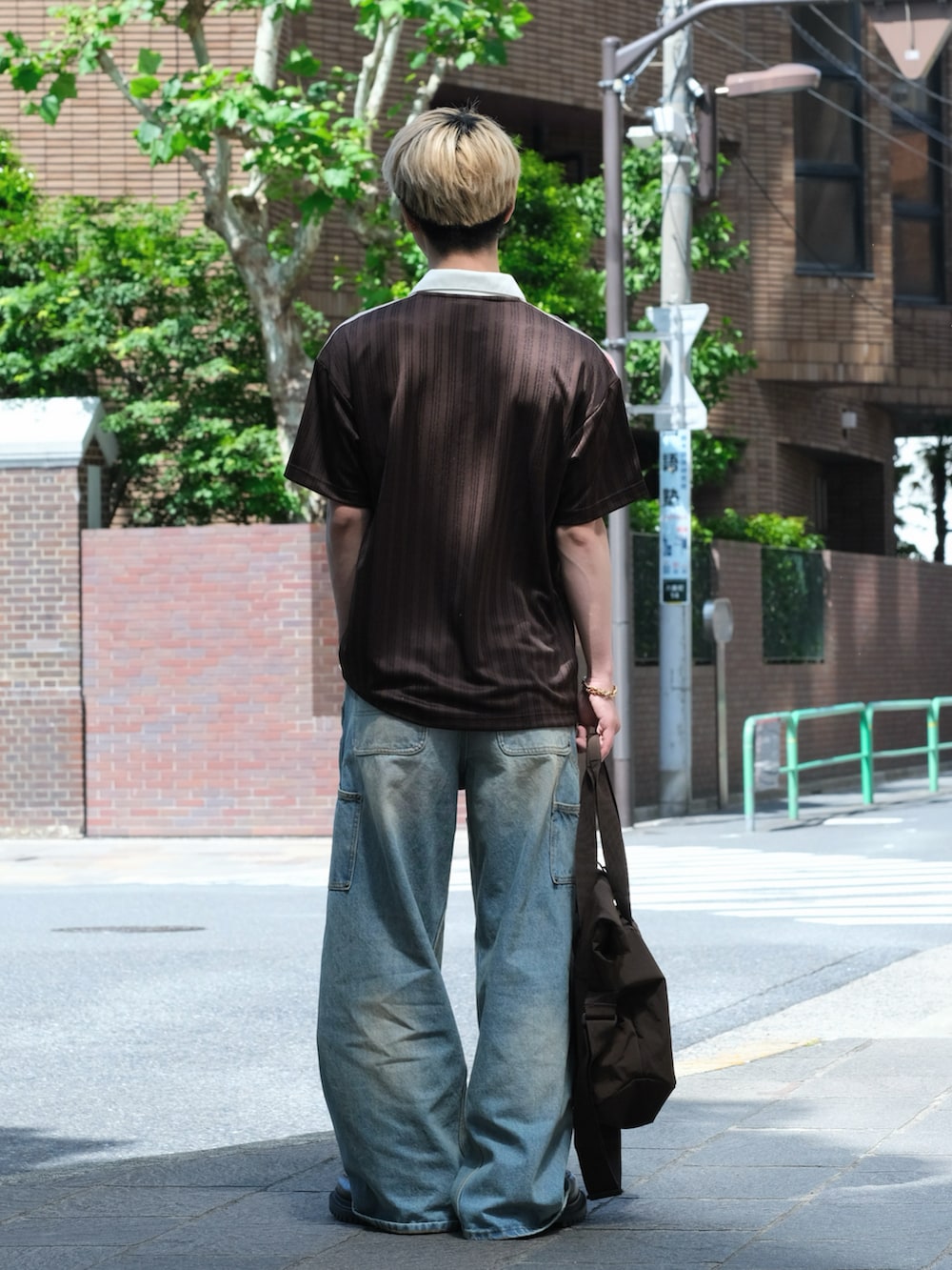 ブラウン系のTシャツ/カットソー、ブルー系のデニムパンツ、ブラウン系のシューズを着用したメンズの夏コーディネートの3枚目の写真