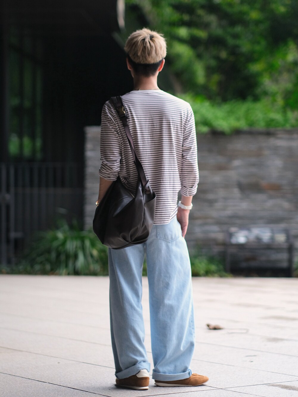 レッド系のTシャツ/カットソー、ブルー系のデニムパンツ、ブラウン系のショルダーバッグを着用したメンズの夏コーディネートの5枚目の写真