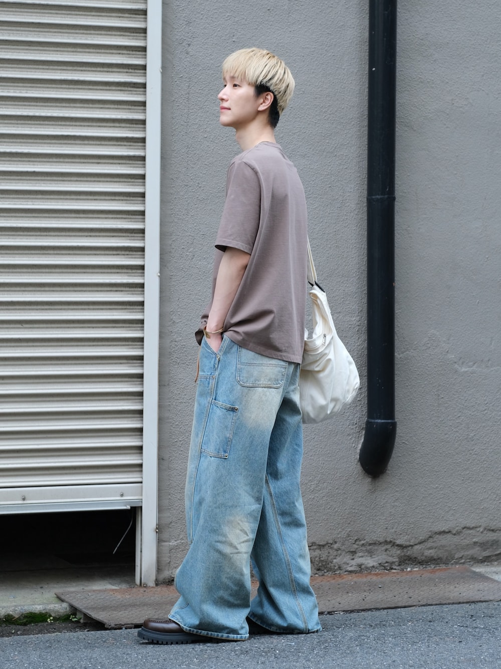 ブルー系のデニムパンツ、ブラウン系のTシャツ/カットソー、ホワイト系のショルダーバッグを着用したメンズの夏コーディネートの4枚目の写真