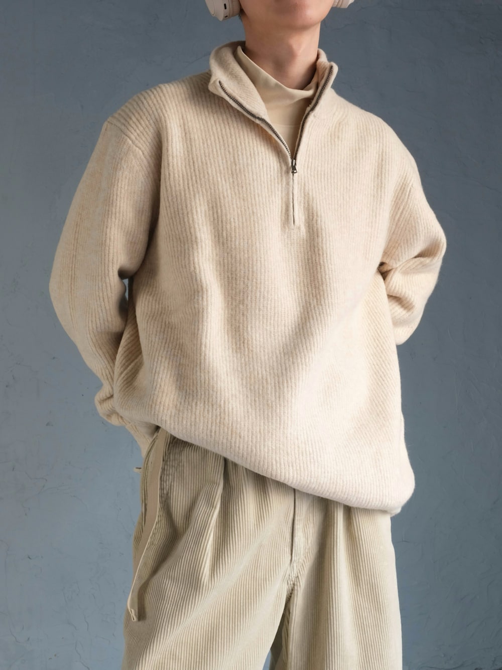 ホワイト系のニット/セーター、ベージュ系のその他パンツ、ホワイト系のスニーカーを着用したメンズの冬コーディネートの3枚目の写真