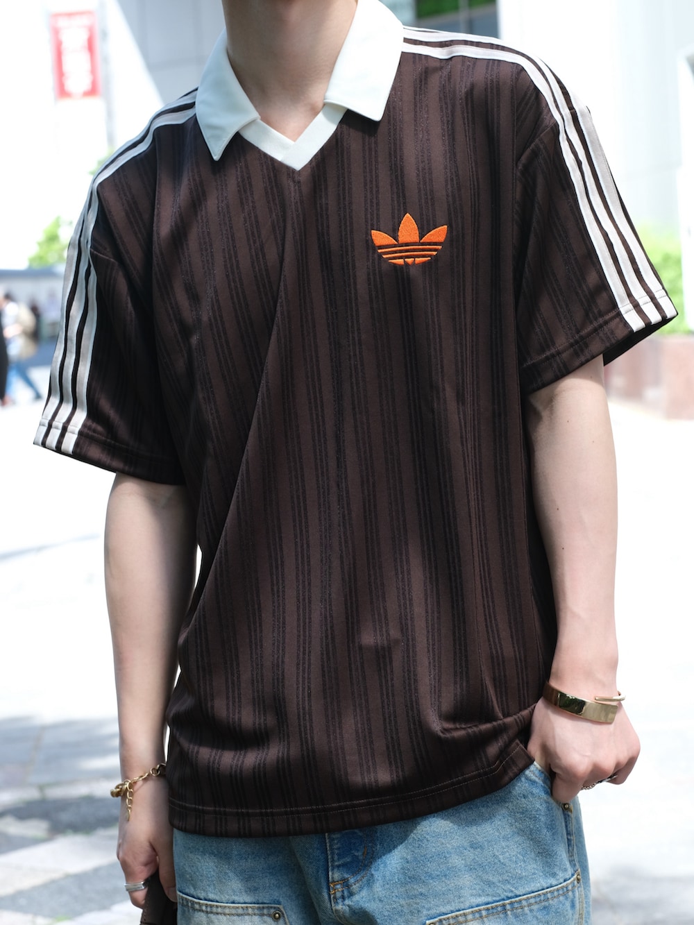 ブラウン系のTシャツ/カットソー、ブルー系のデニムパンツ、ブラウン系のシューズを着用したメンズの夏コーディネートの5枚目の写真