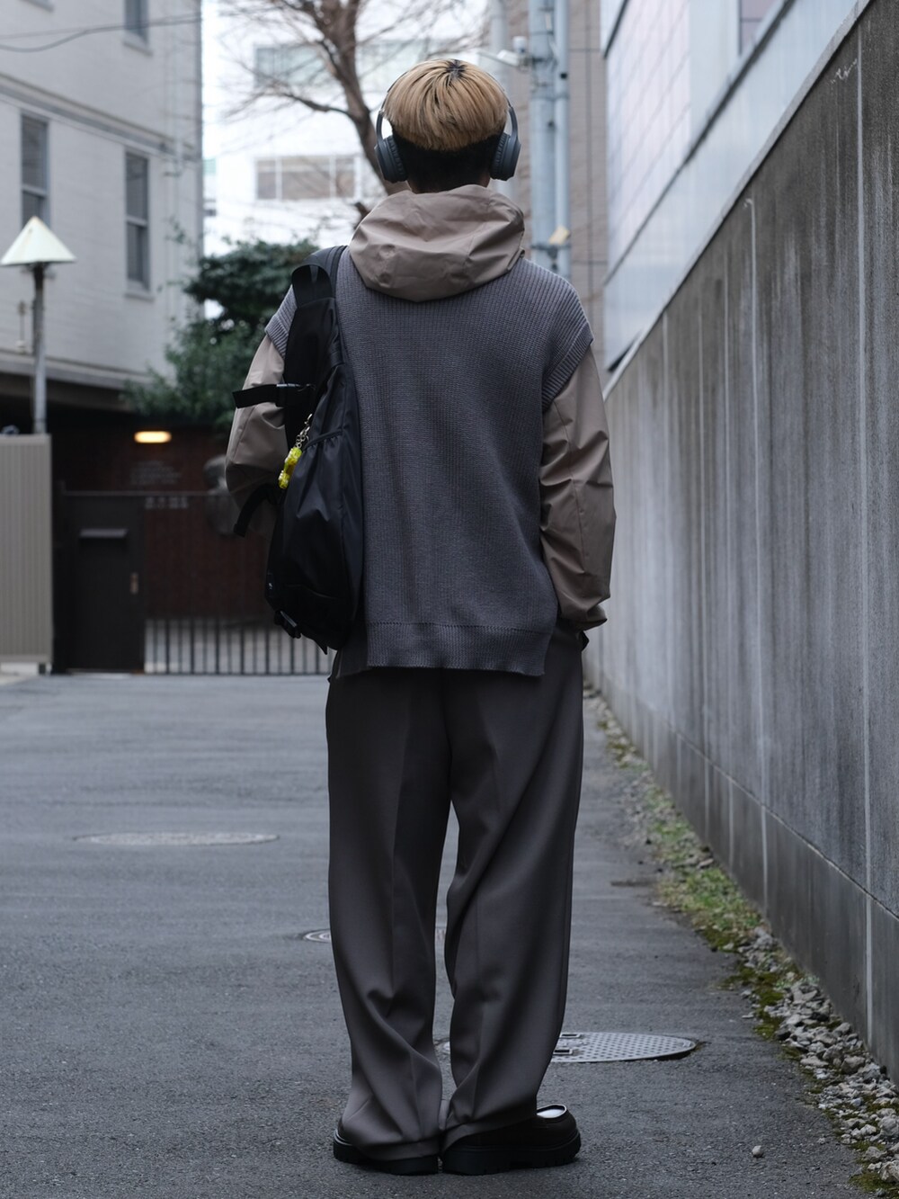 ブルー系のベスト、グレー系のスラックス、ブラウン系のローファーを着用したメンズの春コーディネートの3枚目の写真