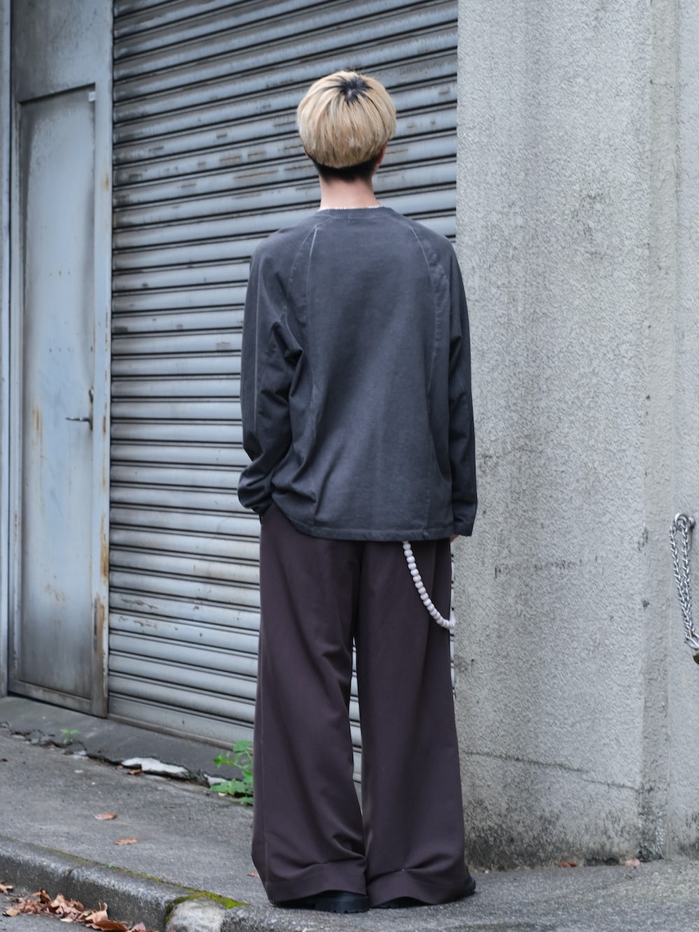 ブラック系のTシャツ/カットソー、ブラウン系のスラックス、ブラウン系のシューズを着用したメンズの夏コーディネートの4枚目の写真