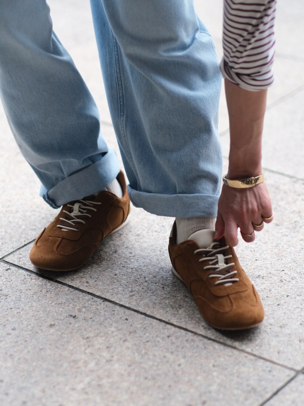 レッド系のTシャツ/カットソー、ブルー系のデニムパンツ、ブラウン系のショルダーバッグを着用したメンズの夏コーディネートの4枚目の写真