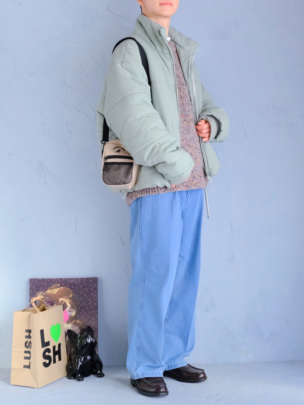 ブラウン系のローファー、ブルー系のデニムパンツ、グレー系のニット/セーターを着用したメンズの冬コーディネートの2枚目の写真