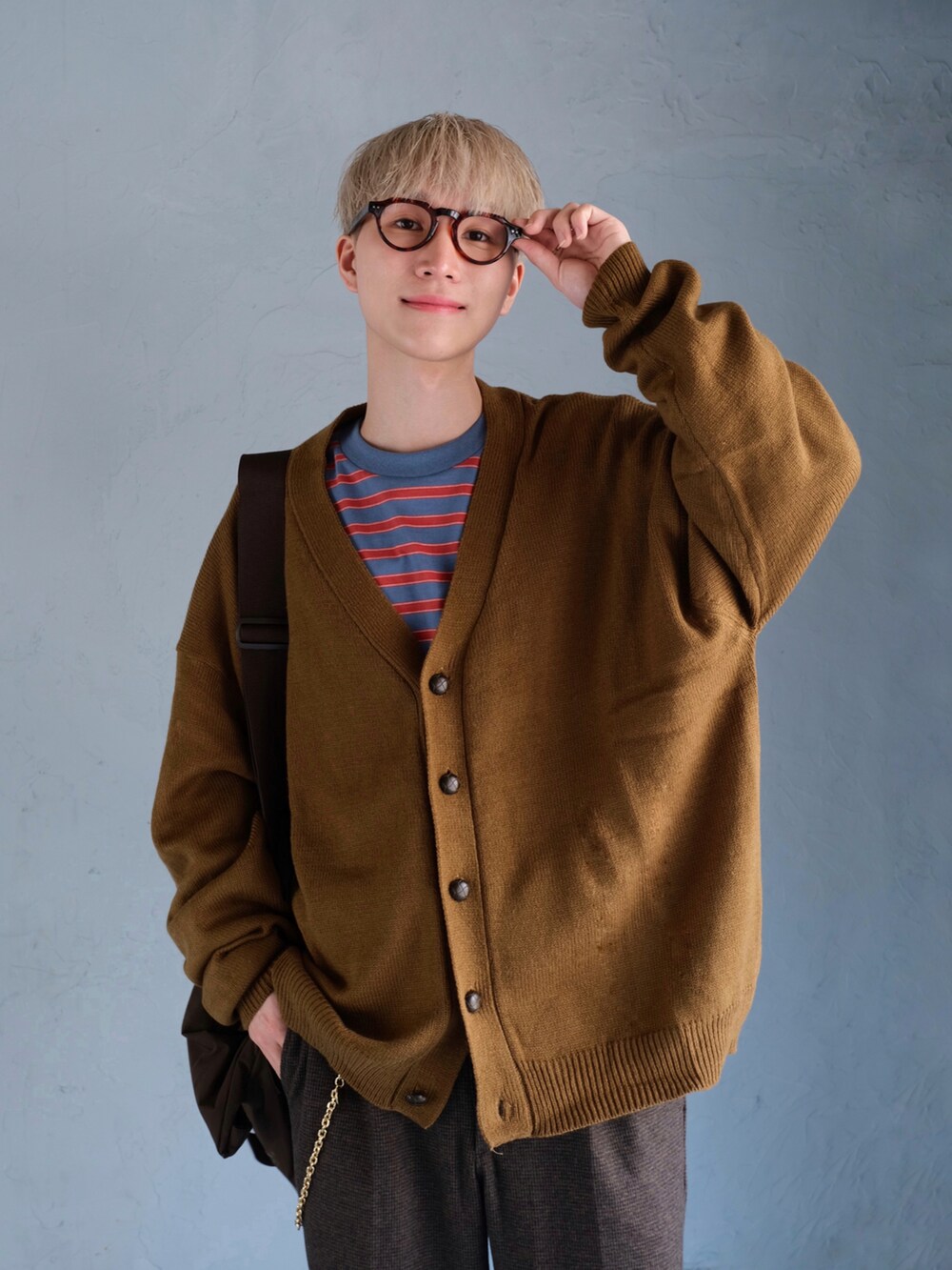 ブルー系のTシャツ/カットソー、イエロー系のカーディガン/ボレロ、ブラウン系のスラックスを着用したメンズの秋コーディネートの3枚目の写真