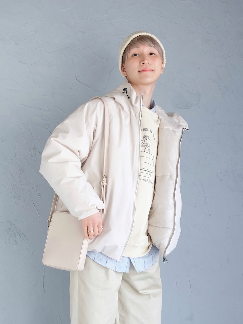 レッド系のスニーカー、ベージュ系のチノパンツ、ホワイト系のスウェットを着用したメンズの冬コーディネートの2枚目の写真