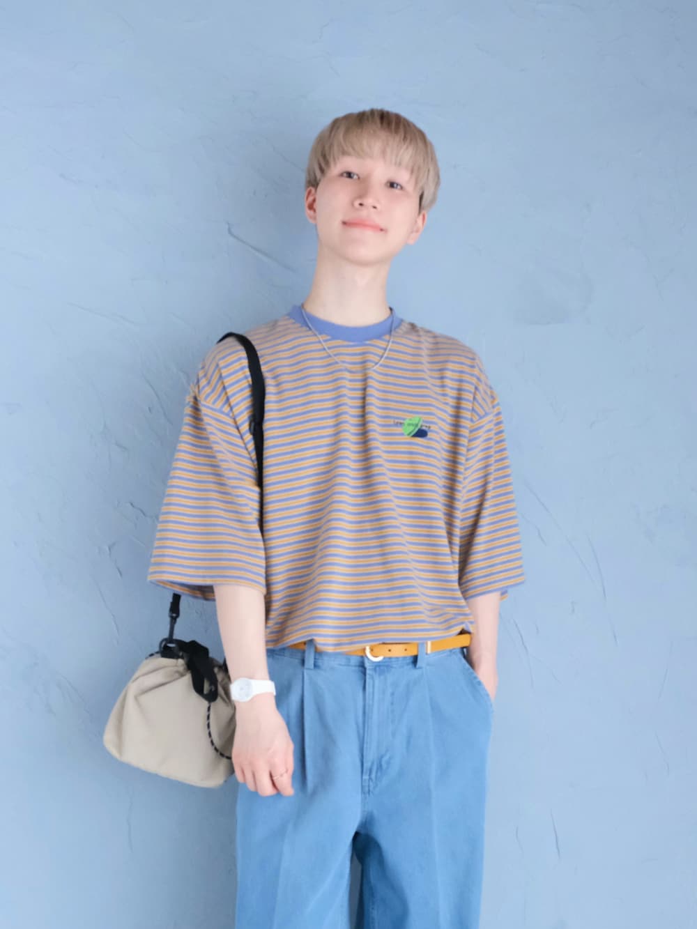 ホワイト系のサンダル、ブルー系のデニムパンツ、ベージュ系のショルダーバッグを着用したメンズの夏コーディネートの2枚目の写真