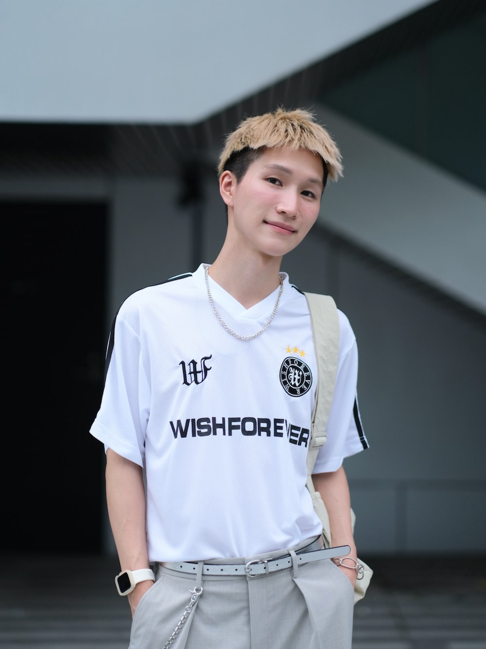 ホワイト系のTシャツ/カットソー、グレー系のスラックス、ホワイト系のスニーカーを着用したメンズの夏コーディネートの2枚目の写真