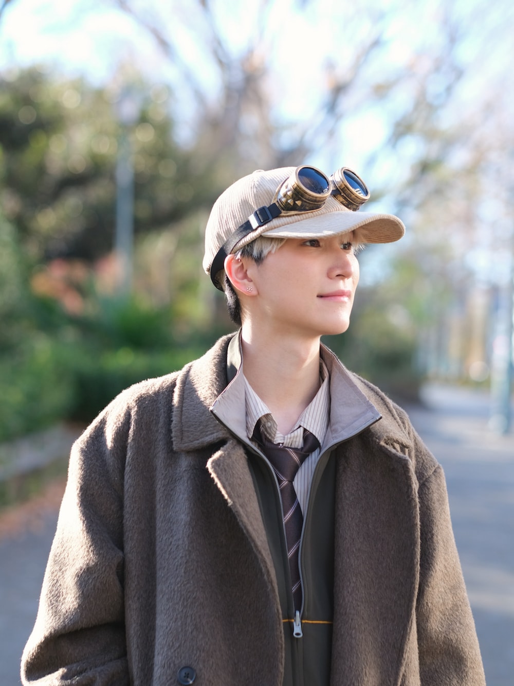 ブラウン系のチェスターコート、グリーン系のスウェットパンツ、ブラウン系のローファーを着用したメンズの冬コーディネートの2枚目の写真