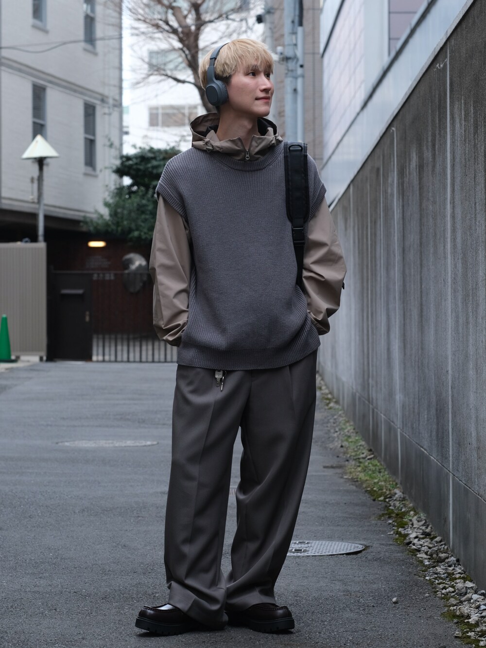 ブルー系のベスト、グレー系のスラックス、ブラウン系のローファーを着用したメンズの春コーディネートの5枚目の写真