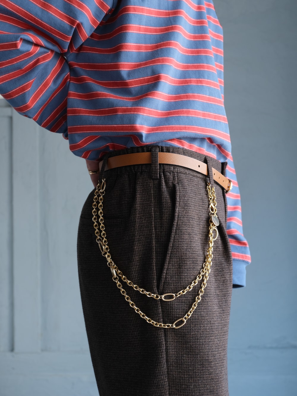 ブルー系のTシャツ/カットソー、イエロー系のカーディガン/ボレロ、ブラウン系のスラックスを着用したメンズの秋コーディネートの5枚目の写真