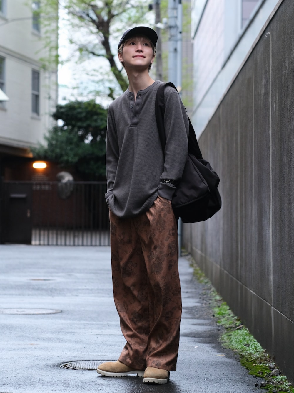 ブラウン系のその他パンツ、ベージュ系のブーツ、ブラック系のショルダーバッグを着用したメンズの春コーディネートの2枚目の写真