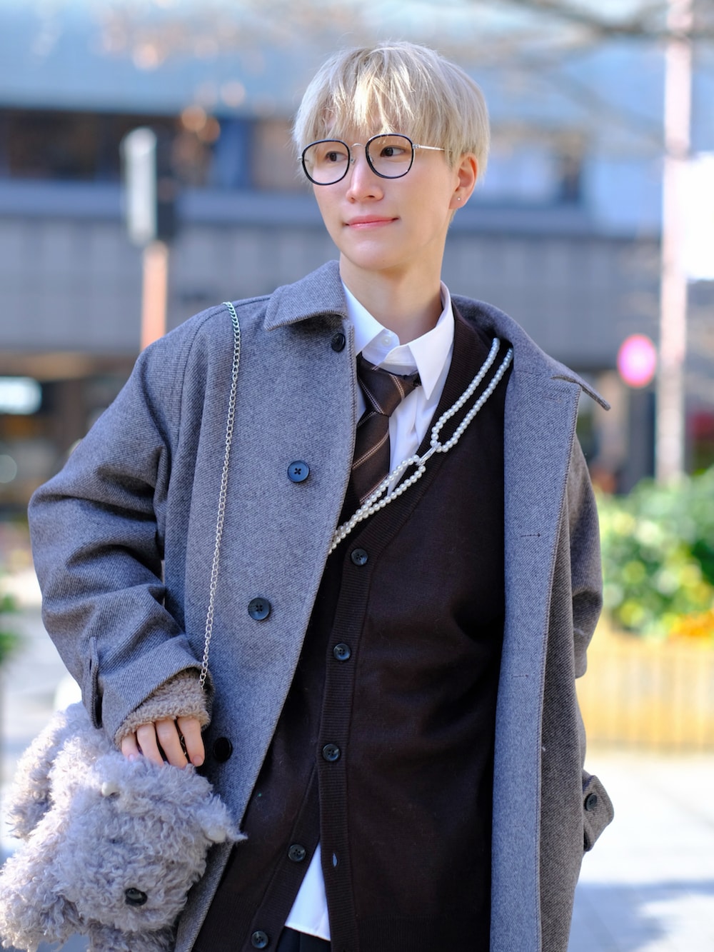 グレー系のショルダーバッグ、グレー系のステンカラーコート、ブラック系のスラックスを着用したメンズの冬コーディネートの2枚目の写真