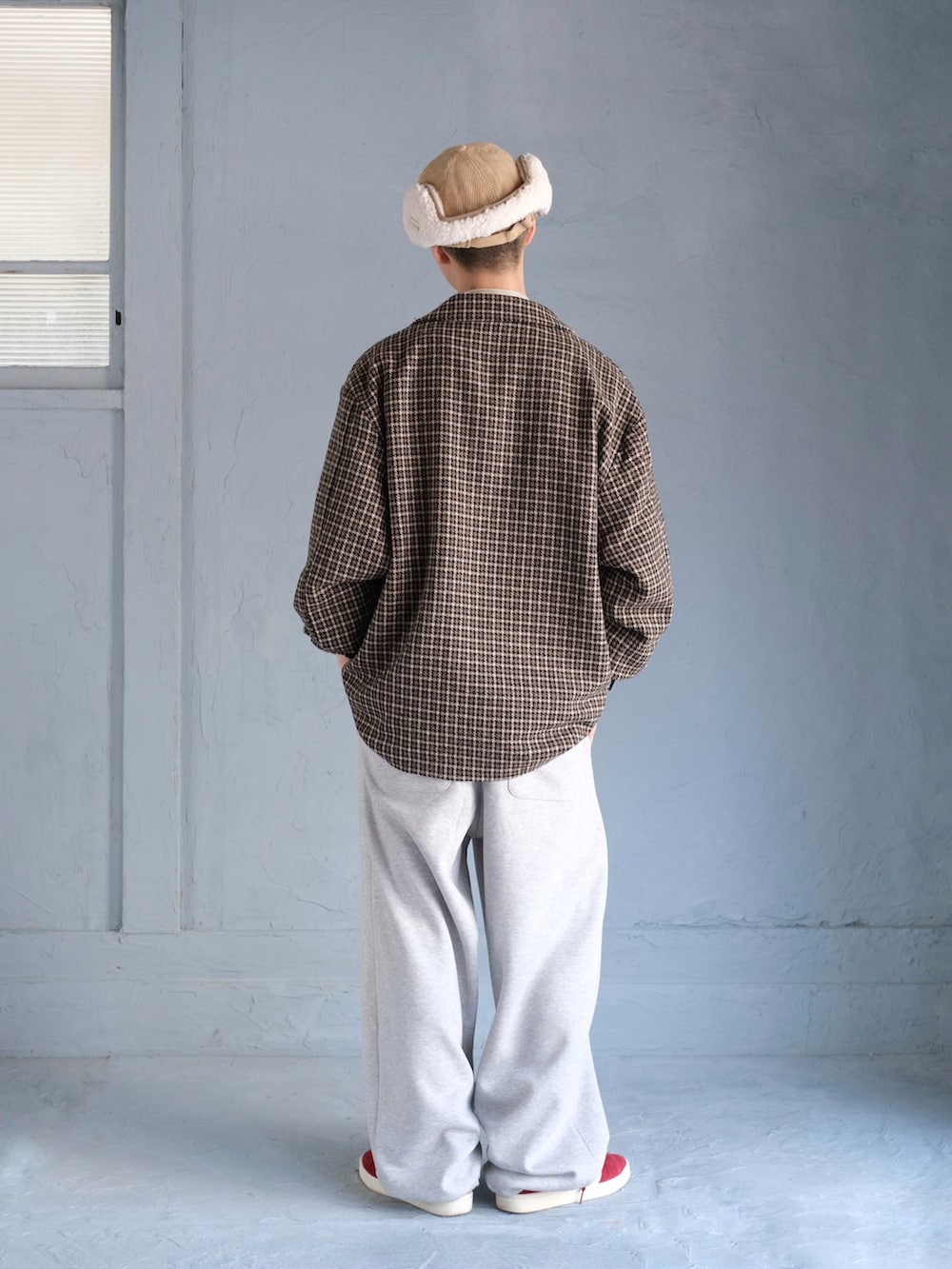 ブラウン系のテーラードジャケット、グレー系のスウェットパンツ、レッド系のスニーカーを着用したメンズの秋コーディネートの5枚目の写真