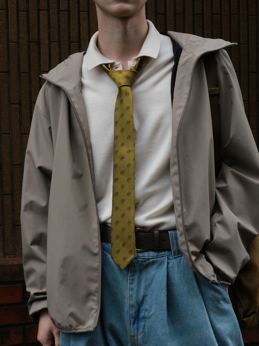 ブルー系のデニムパンツ、イエロー系のネクタイ、ホワイト系のポロシャツを着用したメンズの秋コーディネートの3枚目の写真