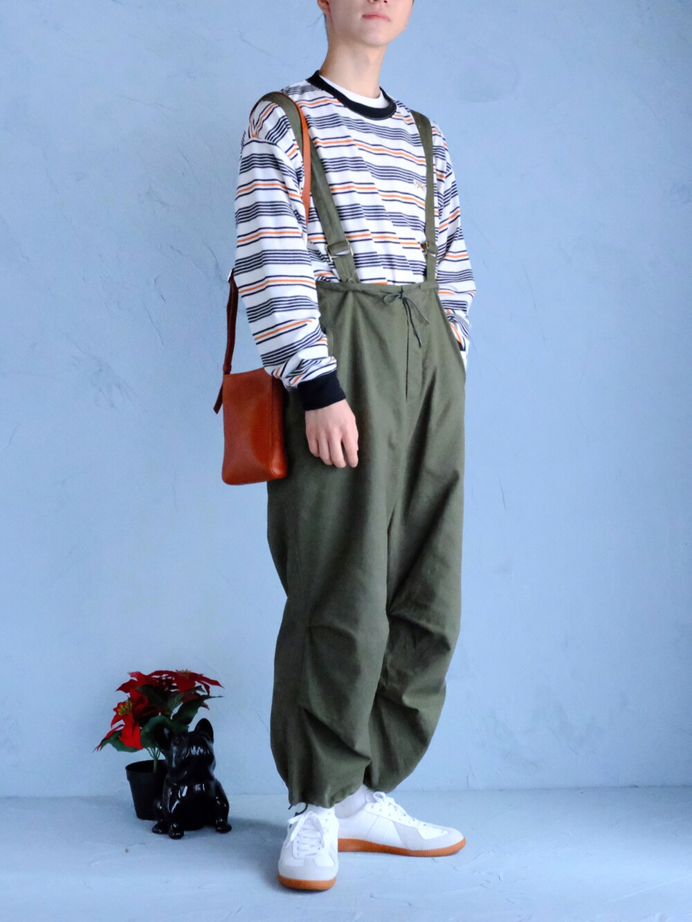 ホワイト系のスニーカー、グリーン系のその他パンツ、ホワイト系のTシャツ/カットソーを着用したメンズの冬コーディネートの2枚目の写真