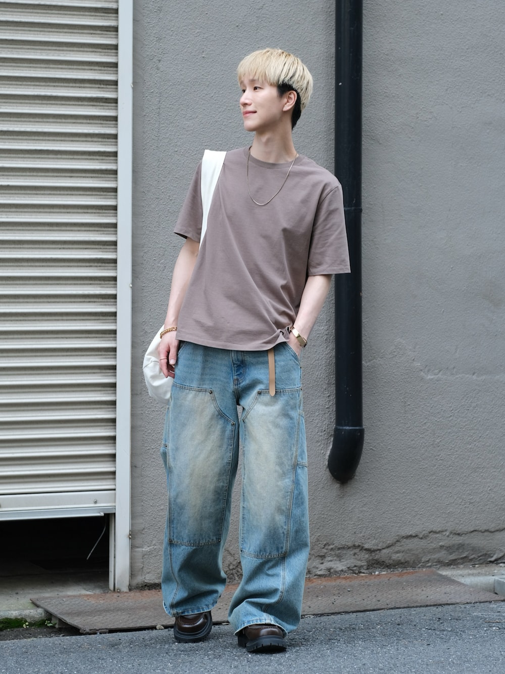 ブルー系のデニムパンツ、ブラウン系のTシャツ/カットソー、ホワイト系のショルダーバッグを着用したメンズの夏コーディネートの2枚目の写真