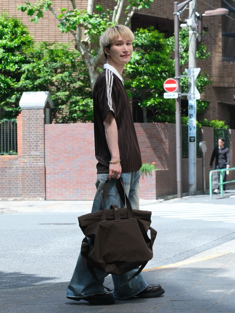 ブラウン系のTシャツ/カットソー、ブルー系のデニムパンツ、ブラウン系のシューズを着用したメンズの夏コーディネートの2枚目の写真