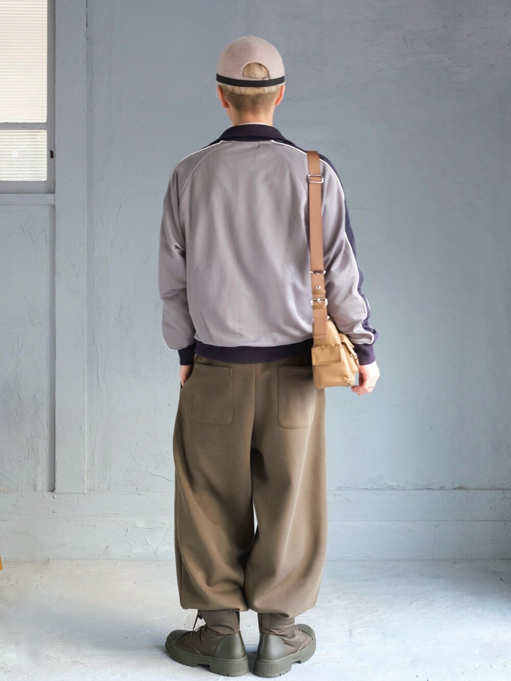 ブルー系のジャージ、ベージュ系のショルダーバッグ、グリーン系のスウェットパンツを着用したメンズの秋コーディネートの5枚目の写真