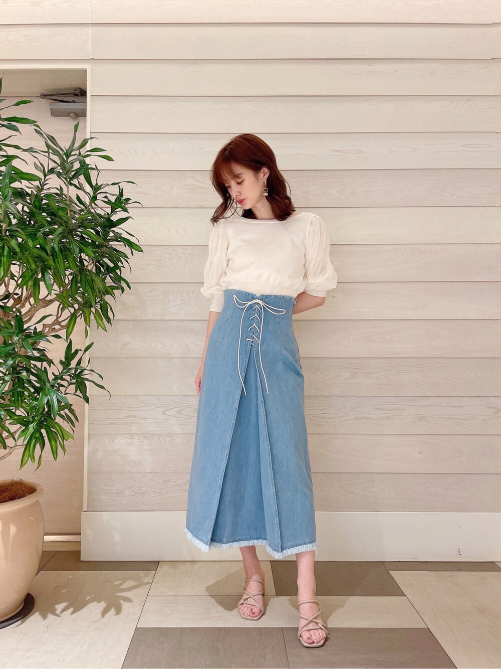 ブルー系のスカート、ホワイト系のカーディガン/ボレロを着用したレディースの春コーディネートの2枚目の写真