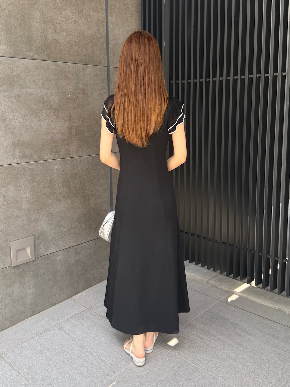 ブラック系のワンピースを着用したレディースの夏コーディネートの4枚目の写真