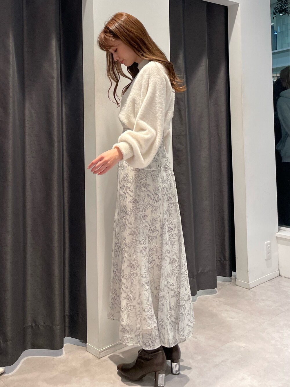 ベージュ系のダウンジャケット/コート、ホワイト系のニット/セーター、ホワイト系のスカートを着用したレディースの秋コーディネートの6枚目の写真