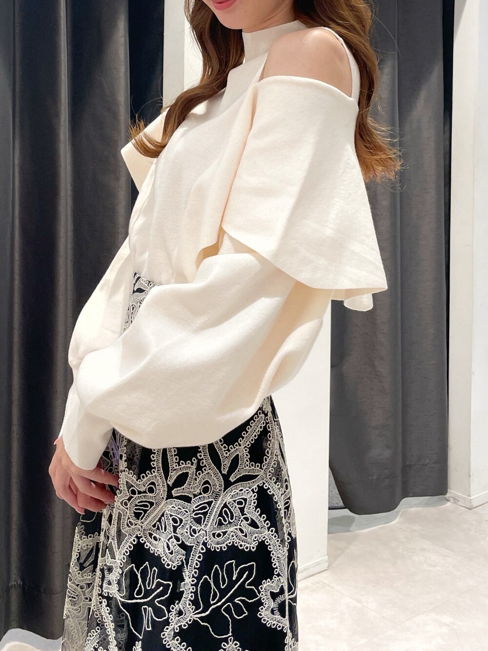 ブラウン系のダウンジャケット/コート、ホワイト系のニット/セーター、ブラック系のスカートを着用したレディースの冬コーディネートの5枚目の写真